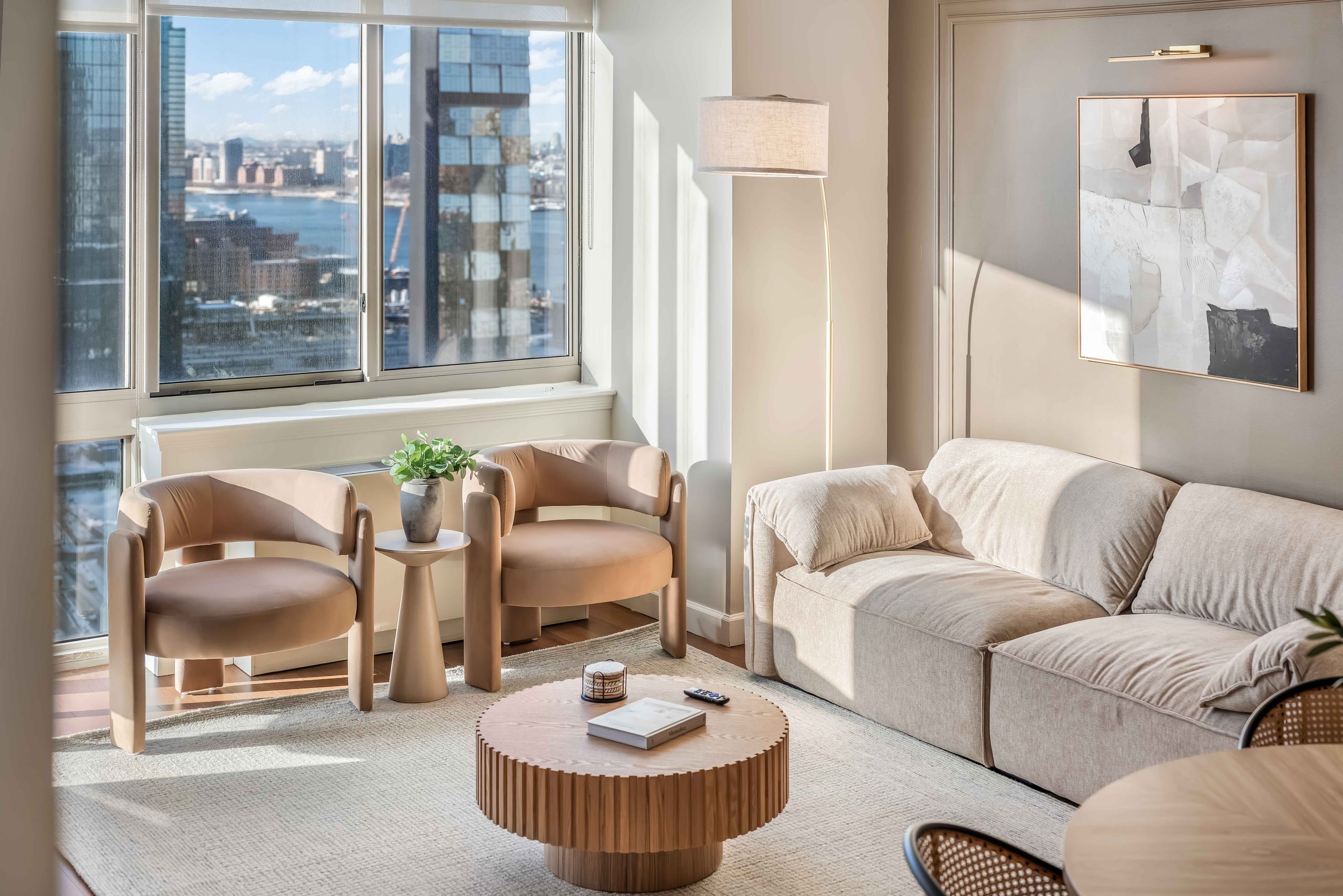 Bright World Class® corporate housing living room with river views through full-height windows